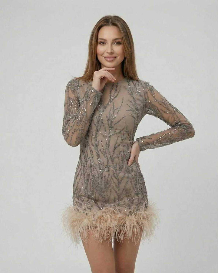 Detalle del mini vestido blanco para mujer, destacando lentejuelas iridiscentes y plumas suaves.