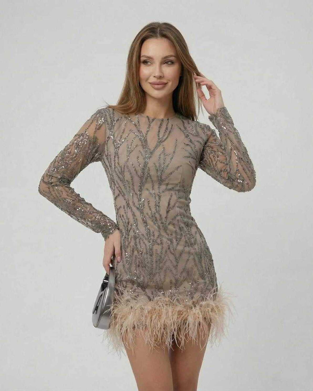 Textura de mini vestido blanco con lentejuelas brillantes y plumas ligeras, ideal para un look festivo.