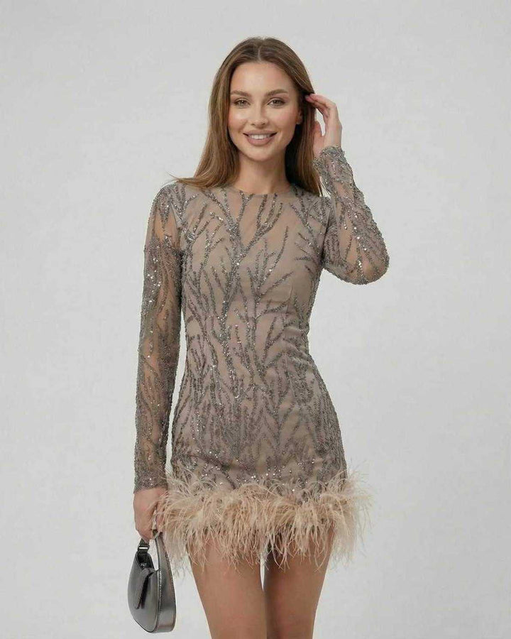 Mujer luciendo mini vestido blanco de cóctel, con lentejuelas y plumas, estilo elegante y moderno.