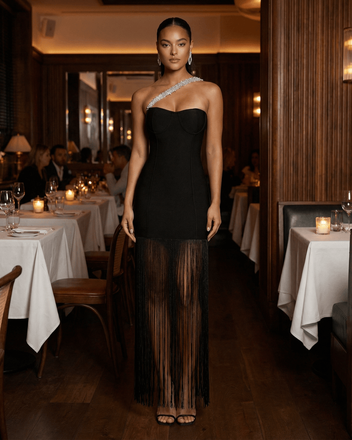 Vestido maxi negro de mujer con un hombro y flecos fluidos, perfecto para destacar en cualquier fiesta formal.
