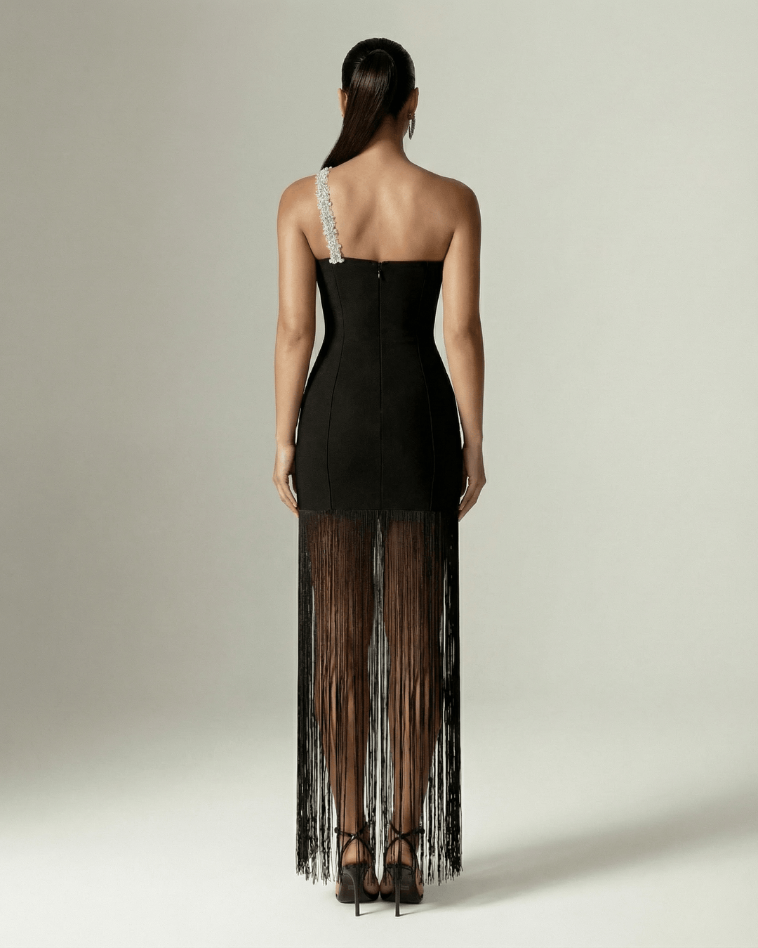 Mujer vistiendo vestido maxi negro de un hombro con flecos, moda femenina elegante perfecto para cóctel y gala.