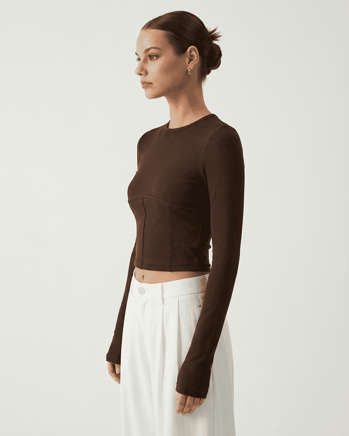 Top corsé de mujer con manga larga, diseño estructurado y versátil para moda otoño-invierno.