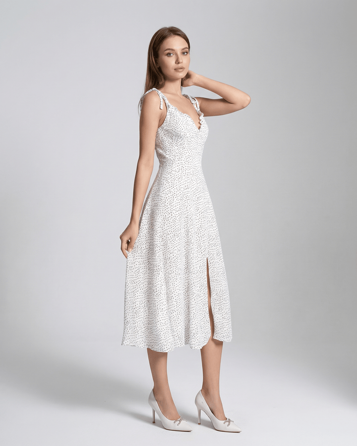 Elegante vestido midi blanco con lunares para mujer, corte A-line sin mangas. Moda de verano para ocasión especial.