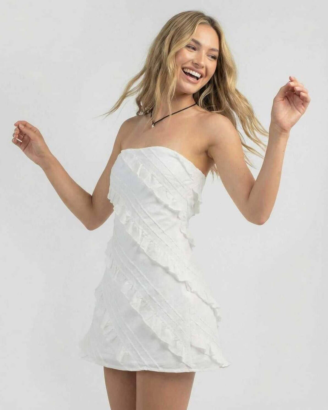 Vestido mini blanco de verano, estilo tubo sin tirantes con volantes. Moda femenina elegante y versátil para cualquier fiesta.