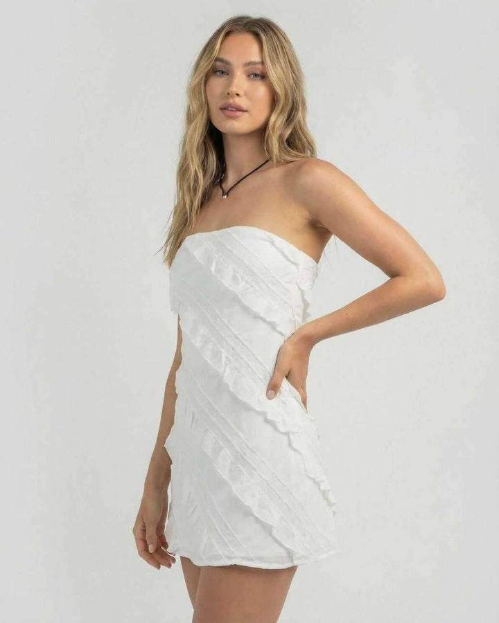 Moderno vestido mini tubo blanco con delicados volantes, sin tirantes. Ropa chic para mujer, ideal para eventos de verano.