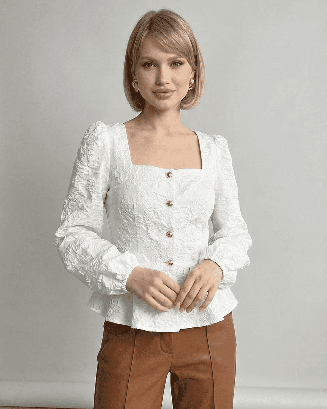 Blusa corsé estructurada marfil con cuello cuadrado y sofisticadas mangas abullonadas.
