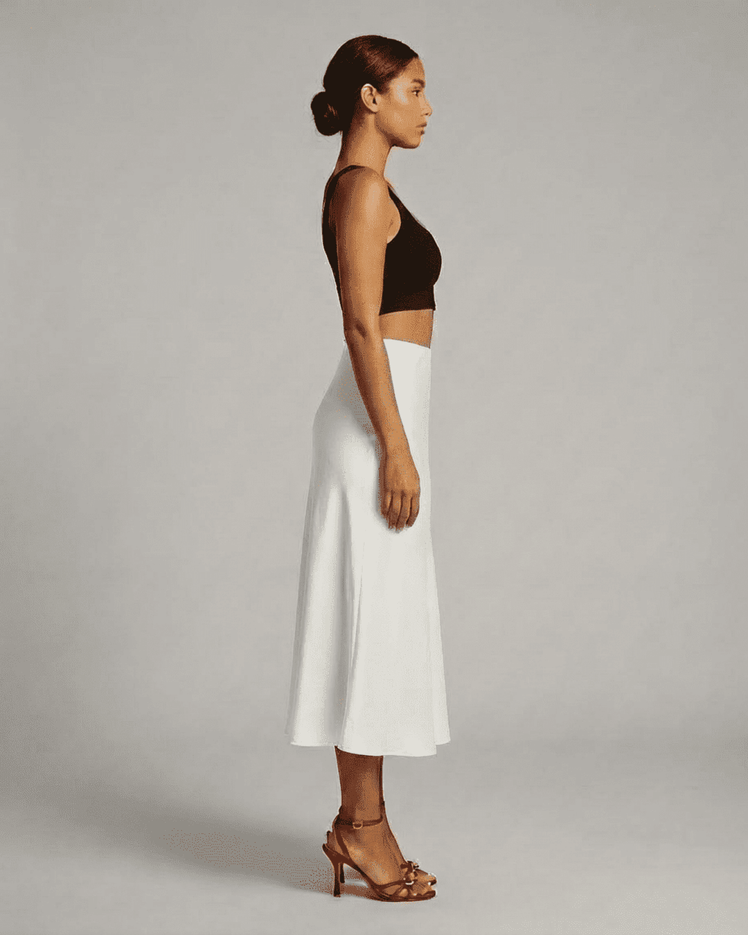 Moda mujer: falda midi blanca sirena con caída fluida. Una prenda elegante de cintura alta para diversas ocasiones.