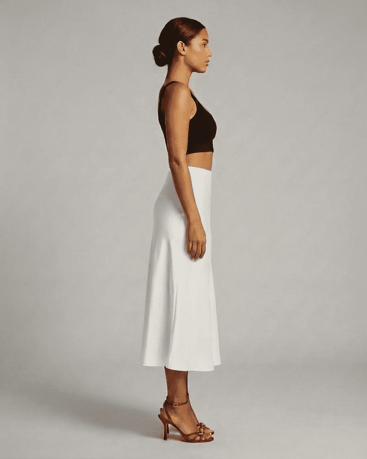 Moda mujer: falda midi blanca sirena con caída fluida. Una prenda elegante de cintura alta para diversas ocasiones.