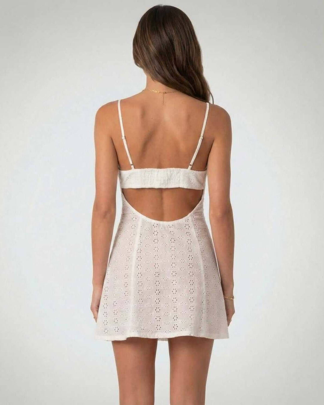 Elegante vestido corto blanco para mujer con escote en V. Diseño sin mangas y detalles recortados.