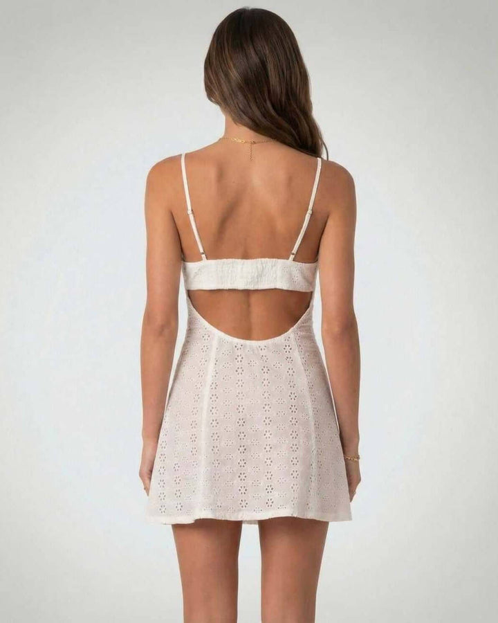 Elegante vestido corto blanco para mujer con escote en V. Diseño sin mangas y detalles recortados.