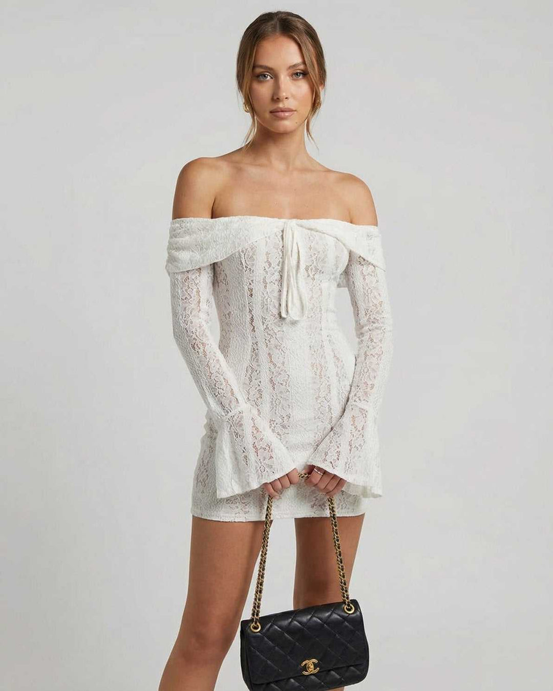 Vestido mini blanco de mujer con hombros descubiertos, ideal para fiestas y eventos elegantes de noche.