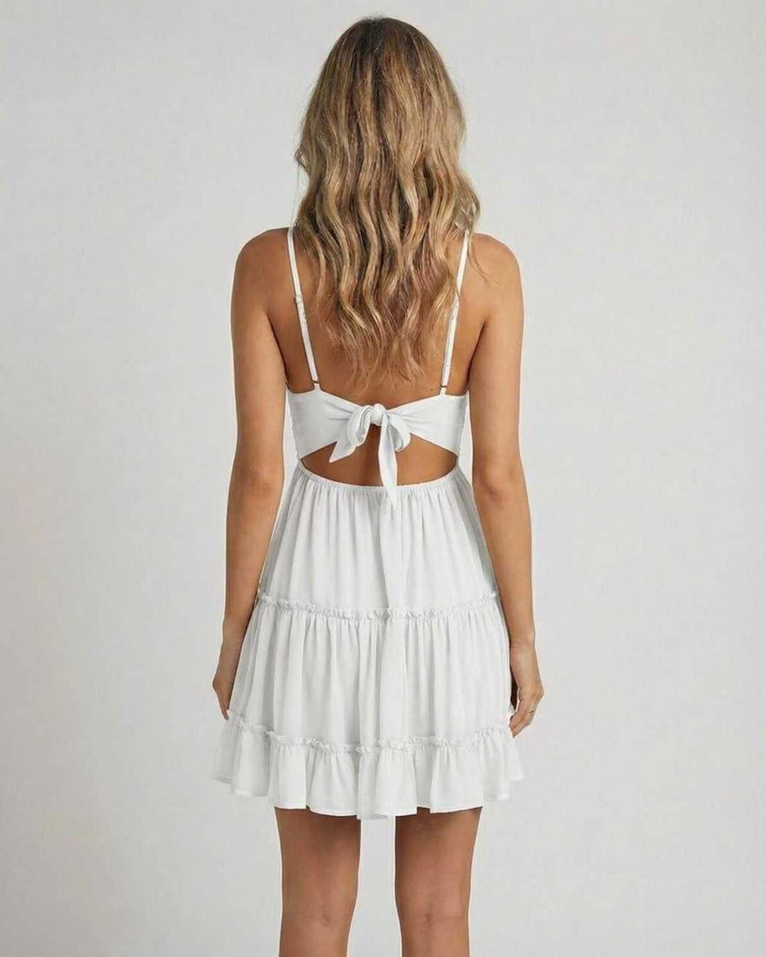 Elegante vestido mini blanco de mujer con escote V y tirantes, ideal para fiestas de verano. Estilo chic.