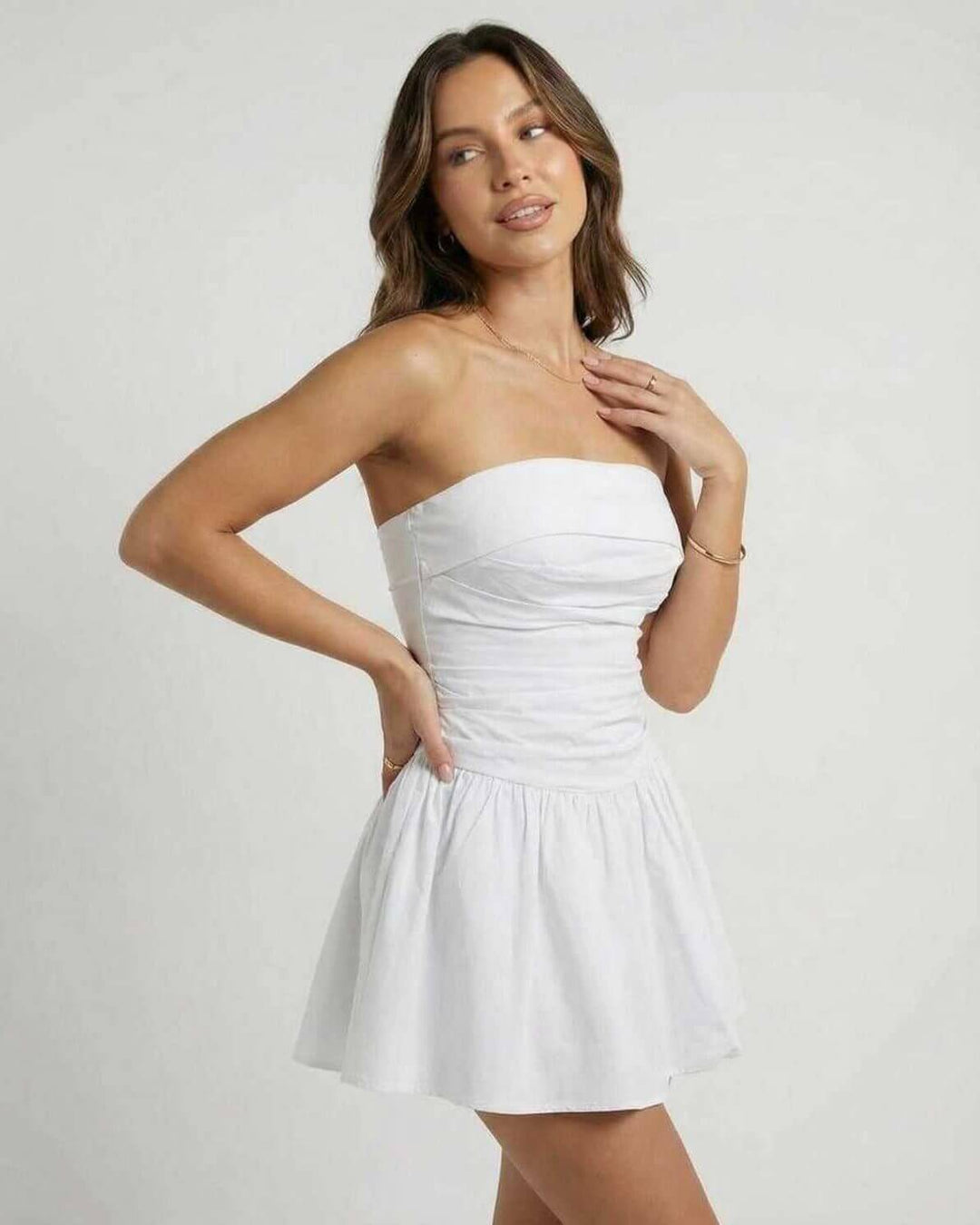 Detalle de vestido mini blanco sin tirantes, acampanado, ideal para la moda de verano femenina y eventos.