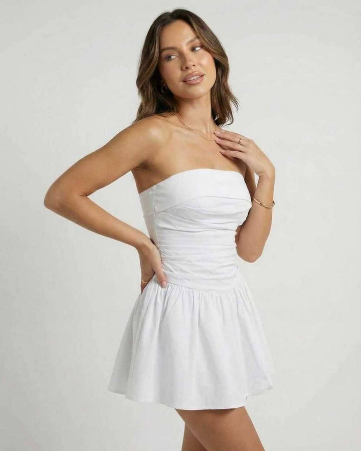 Detalle de vestido mini blanco sin tirantes, acampanado, ideal para la moda de verano femenina y eventos.