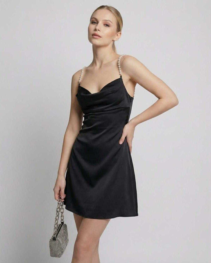 Vestido mini negro de mujer con perlas, corte moderno y sofisticado para fiesta de cóctel.