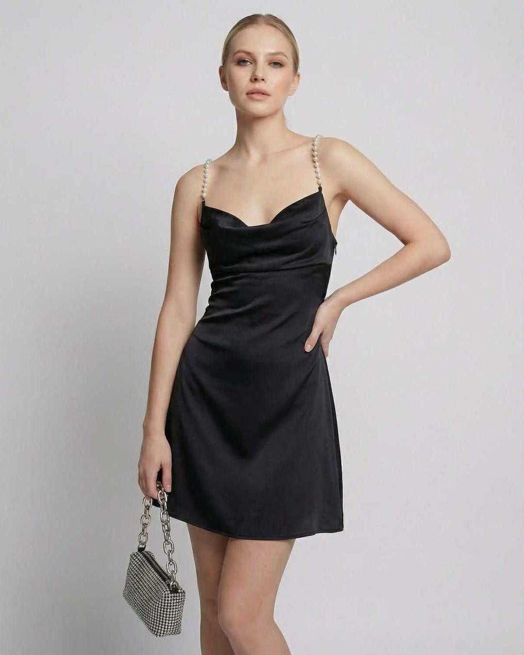 Vestido mini negro de fiesta con perlas, tejido suave y estilo sofisticado de noche.
