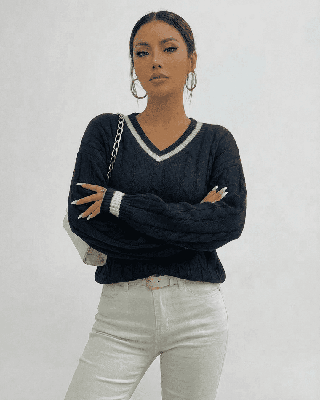 Vista frontal de suéter de punto cableado blanco para mujer, cuello V. Ideal como jersey de otoño-invierno.