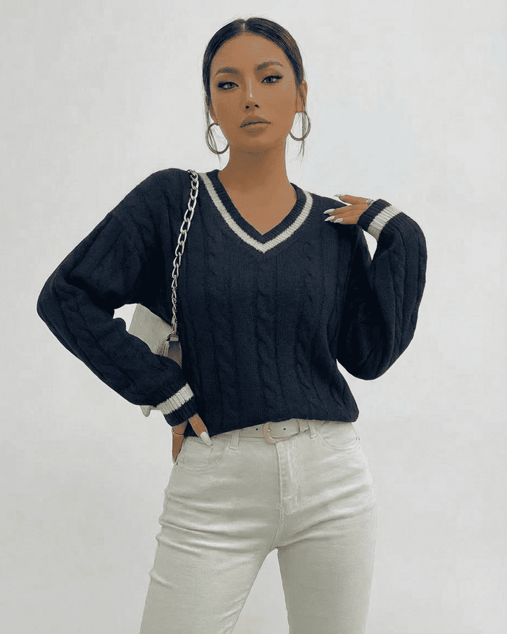 Detalle del suéter blanco de punto cableado para mujer, cuello V. Textura suave y cálida para invierno.