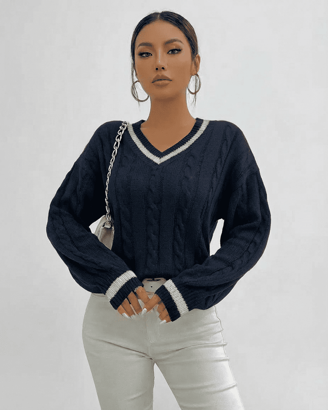 Pullover blanco de punto cableado con cuello V para mujer, perfecto para looks de otoño-invierno.