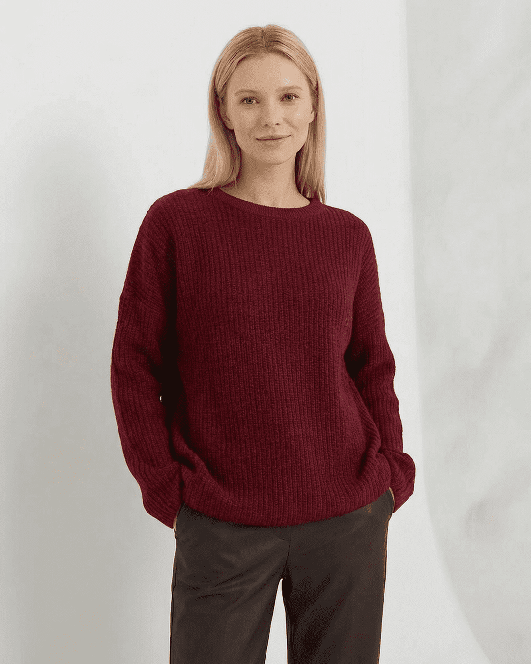 Mujer luciendo suéter burdeos casual, cuello redondo. Ropa cómoda y holgada para un look relajado de invierno.