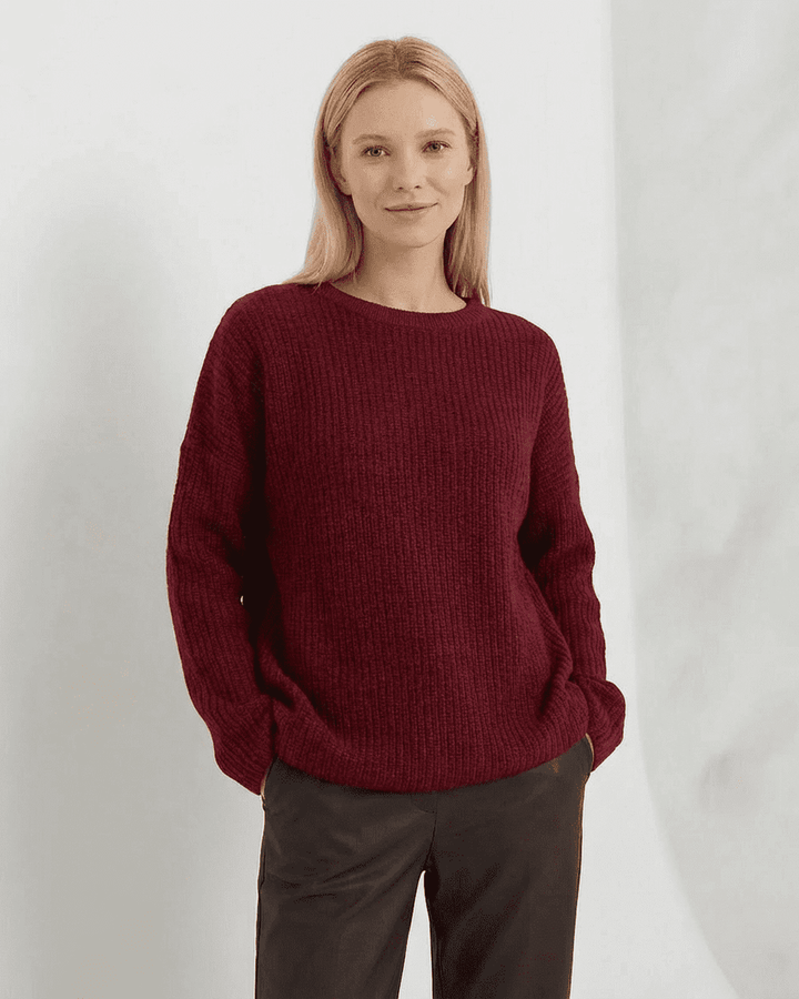 Mujer luciendo suéter burdeos casual, cuello redondo. Ropa cómoda y holgada para un look relajado de invierno.