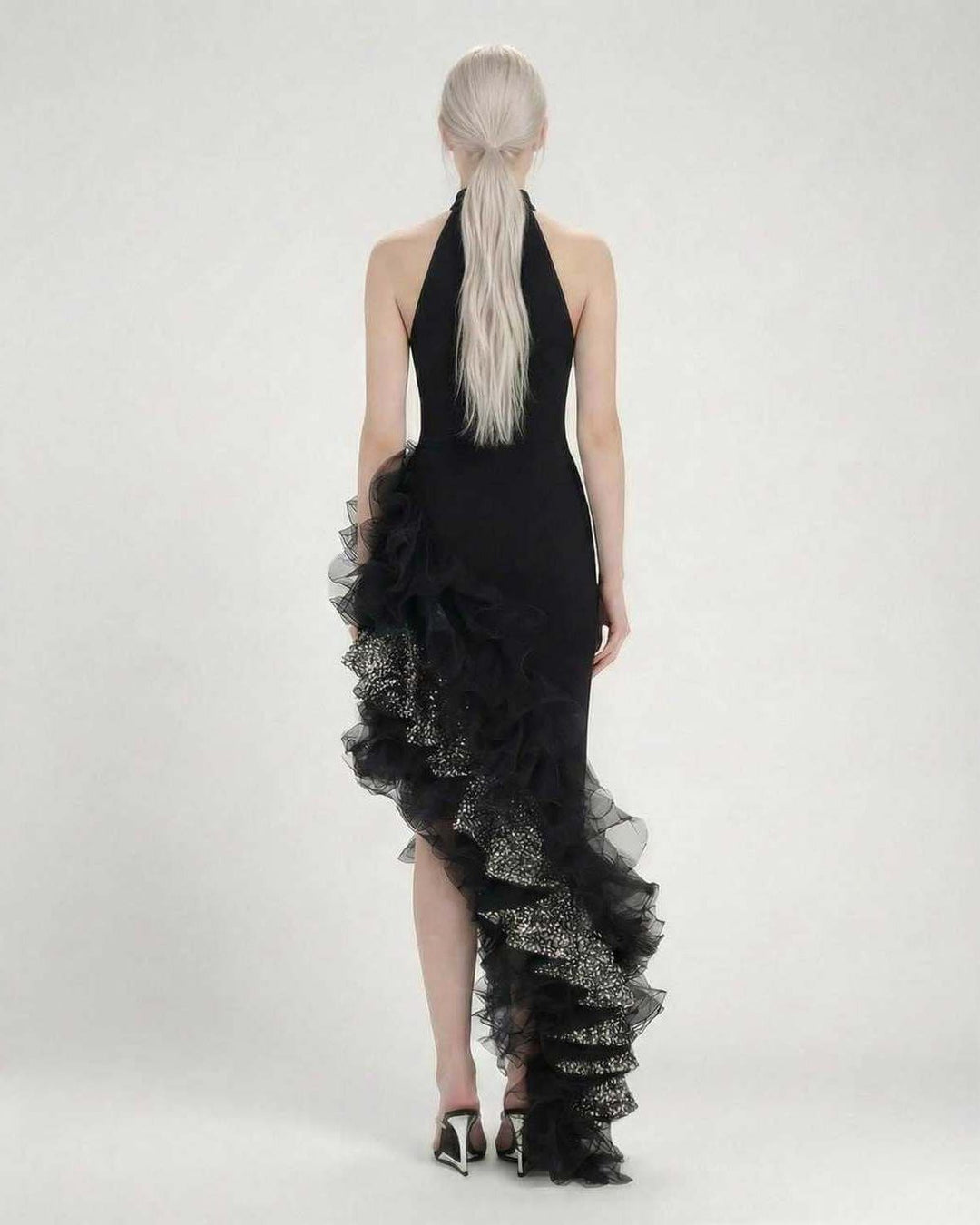 Vestido de noche formal negro con cuello halter y volantes asimétricos, perfecto para eventos especiales de mujer.