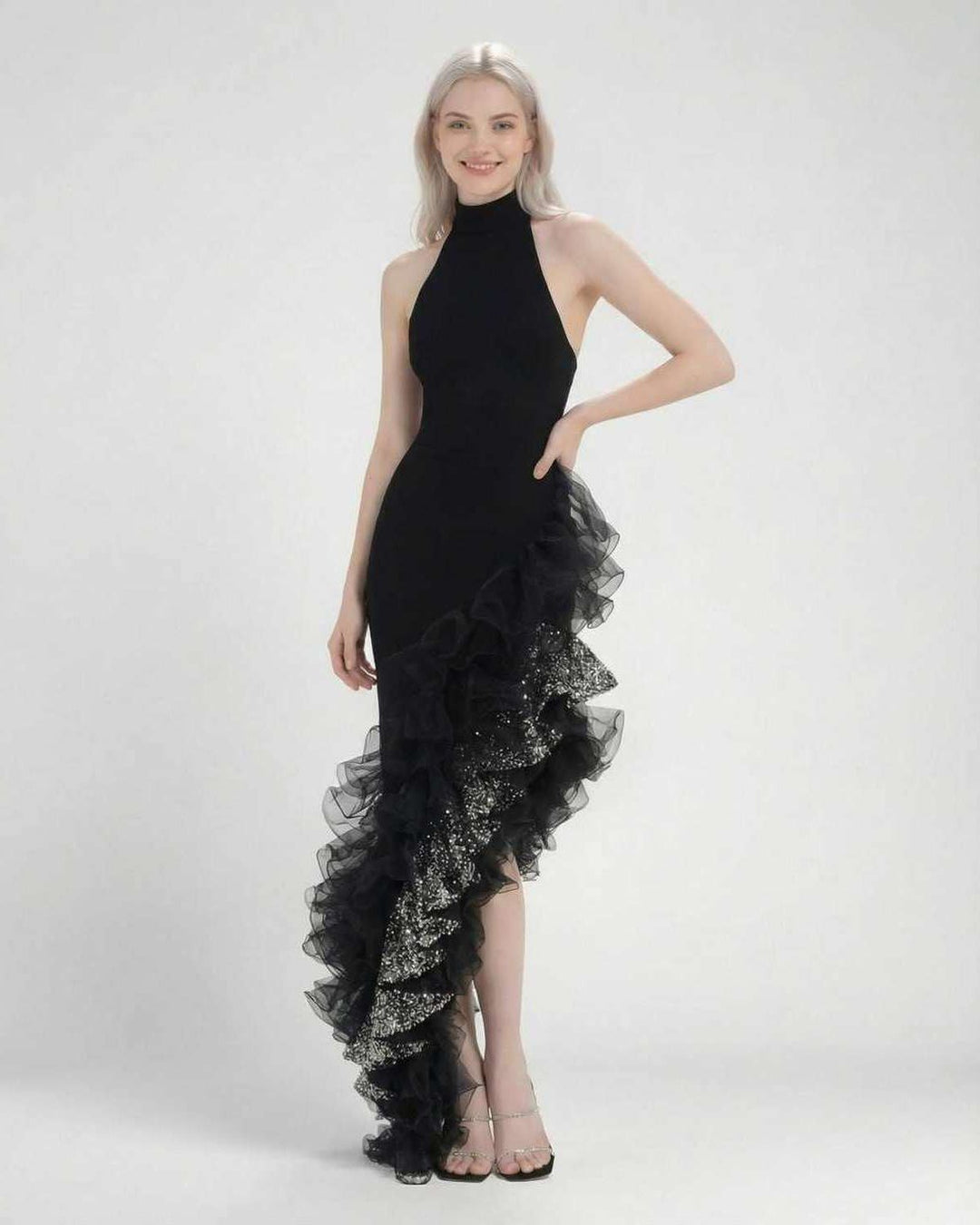 Primer plano de los volantes y el cuello halter de un elegante vestido maxi de noche negro para mujer.