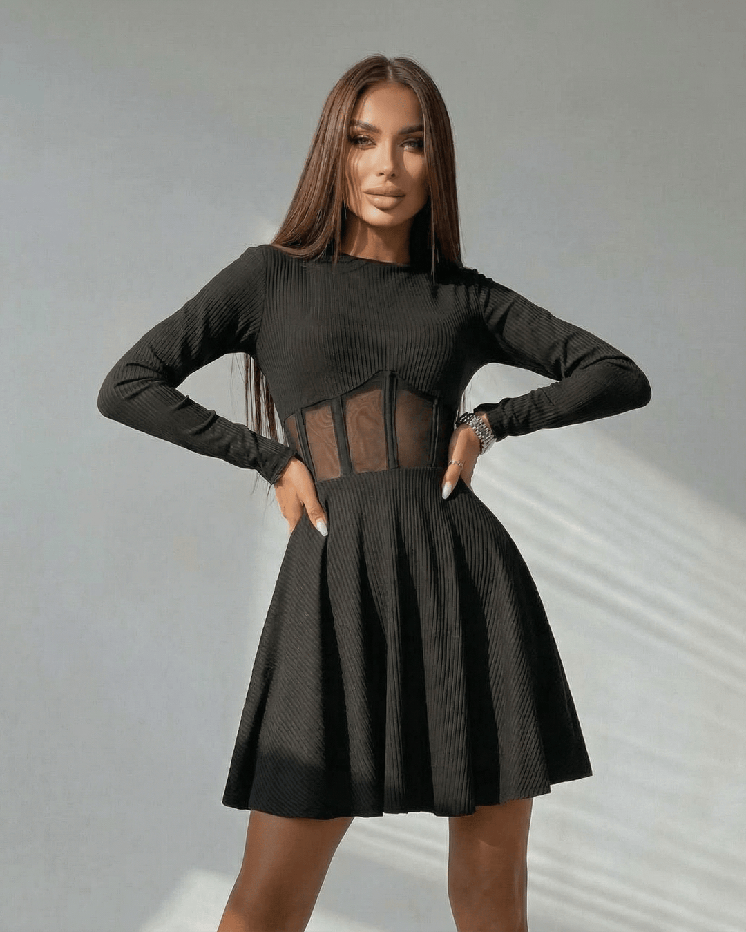 Vestido mini negro de mujer con corsé transparente, mangas largas y silueta A. Ideal para cóctel o fiesta elegante.