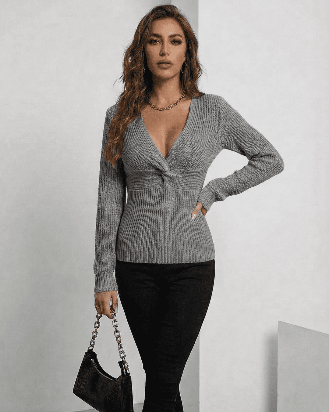 Primer plano de tejido acanalado en suéter Nerina gris de mujer. Cuello en V elegante y ajuste slim.