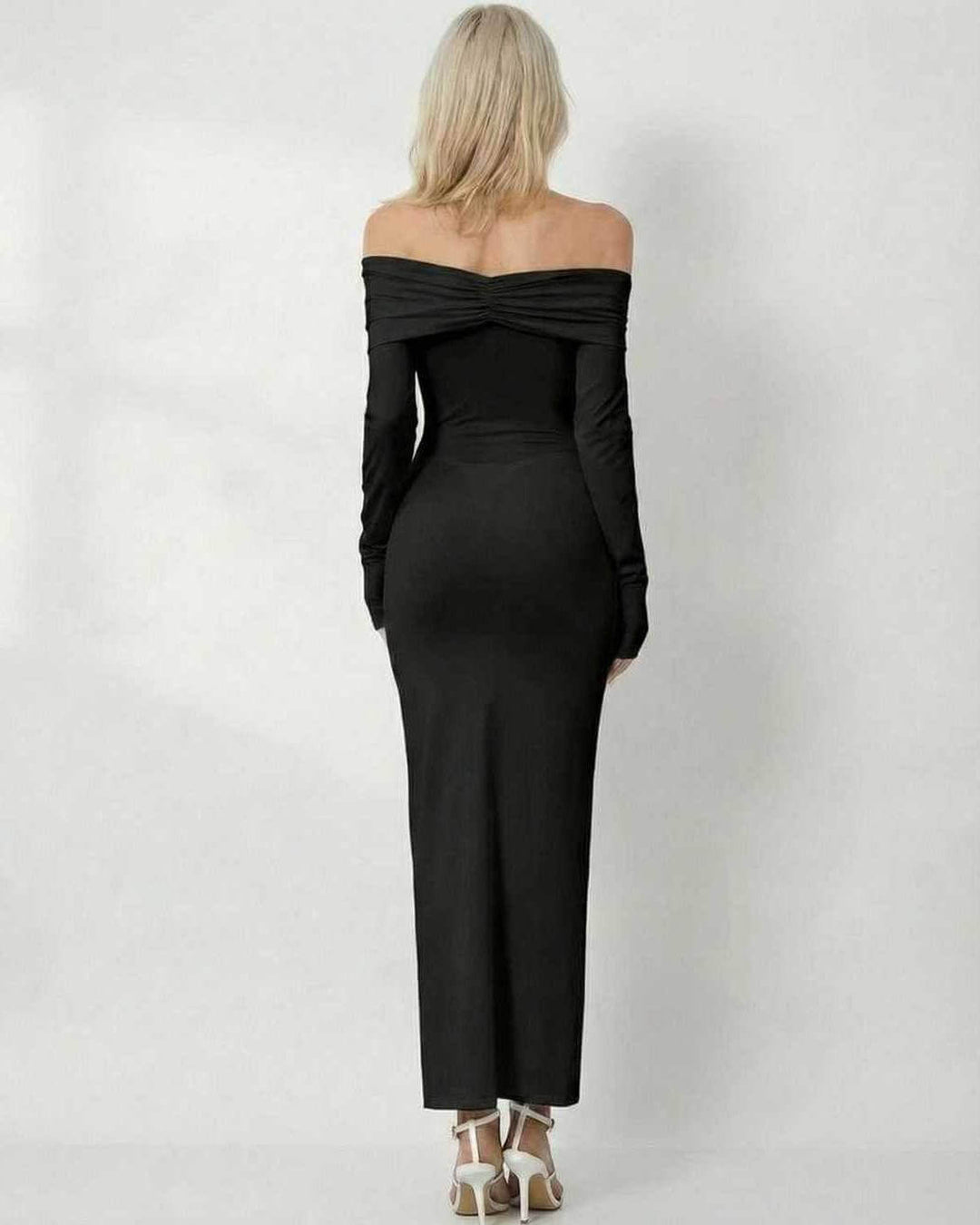 Modelo luciendo vestido maxi negro ceñido sin hombros, perfecto para un look sofisticado de moda noche.
