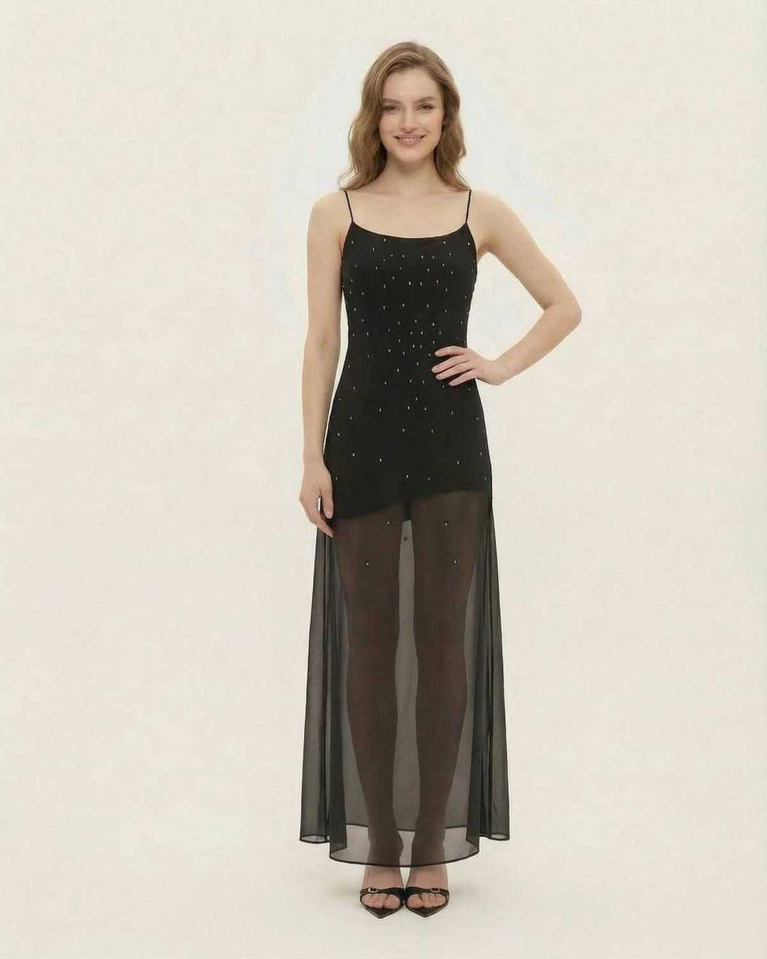 Mujer luciendo un glamuroso vestido maxi negro con brillo. Elegancia para noche, fiesta o evento formal.