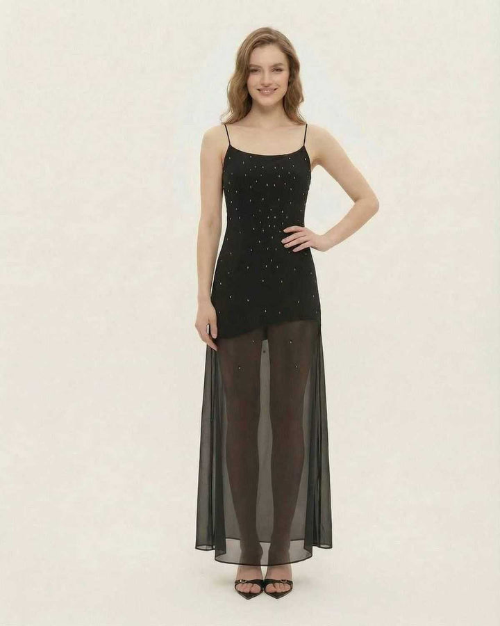 Mujer luciendo un glamuroso vestido maxi negro con brillo. Elegancia para noche, fiesta o evento formal.