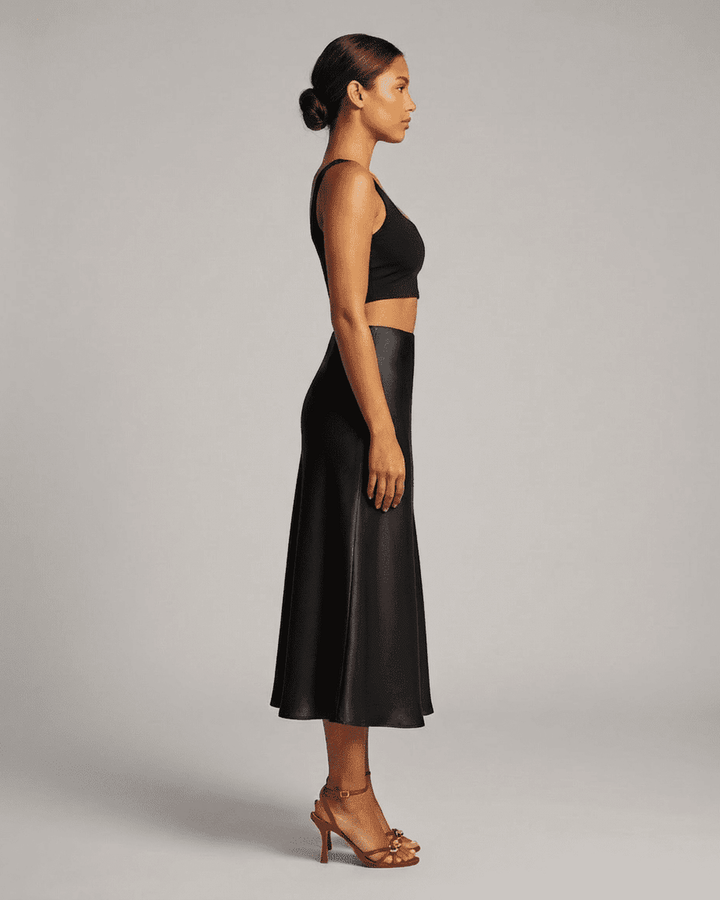 Detalle de falda midi negra sirena, tejido elegante y clásico. Ropa mujer para estilo noche sofisticado.