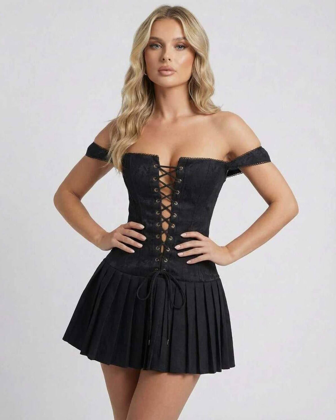 Elegante vestido mini negro con tirantes para mujer. Diseño ceñido y falda plisada, perfecto para noche y fiesta.