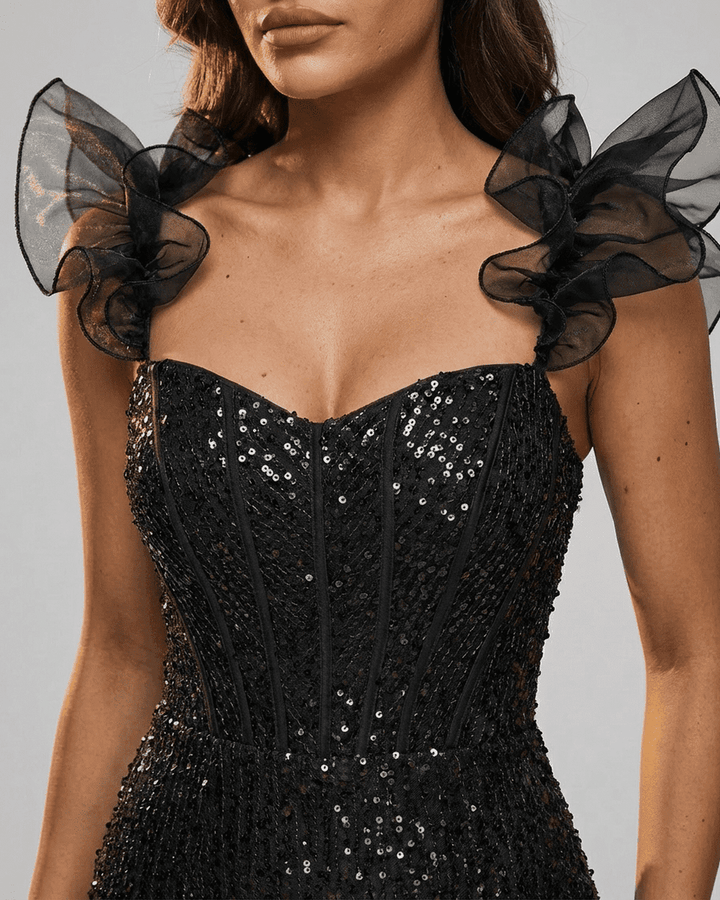 Vestido negro de noche mini con volantes y acabado brillante, ideal para fiestas y ocasiones especiales.