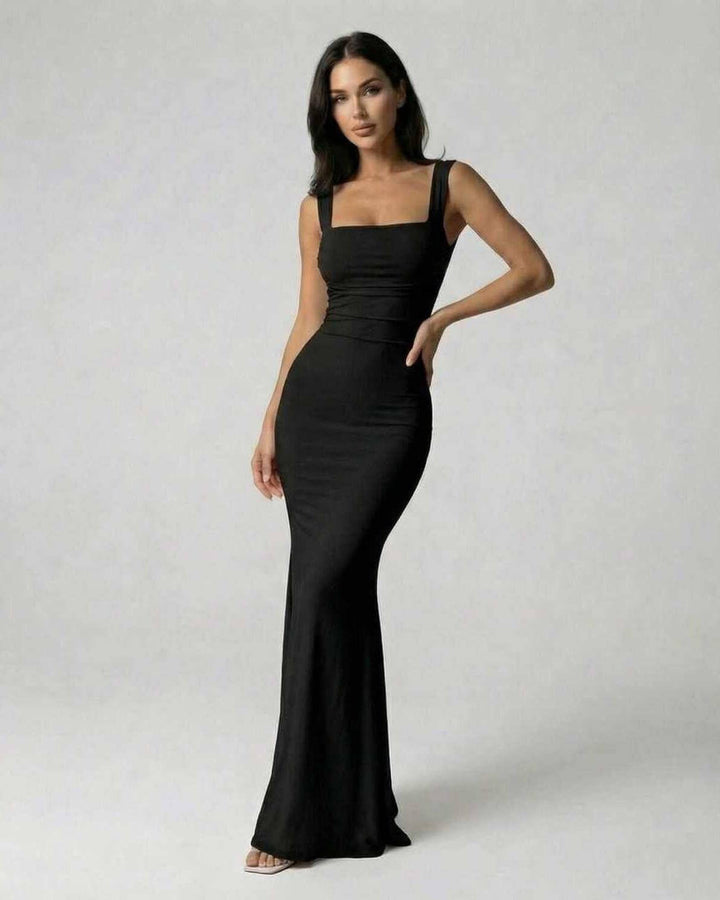 Vestido maxi negro de fiesta que irradia elegancia y estilo, con una espalda cruzada para mujer moderna.