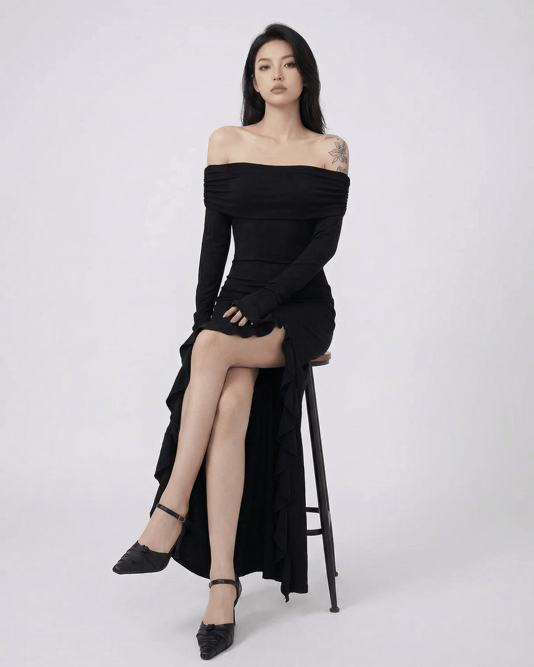 Vestido maxi negro asimétrico con detalle de volantes, una opción chic para fiestas y cócteles.