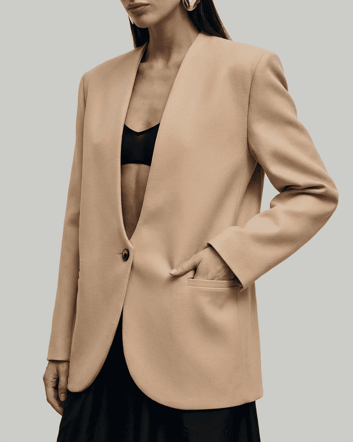 Blazer entallado beige para mujer, vista frontal, diseño elegante, ideal para combinar con atuendos formales.