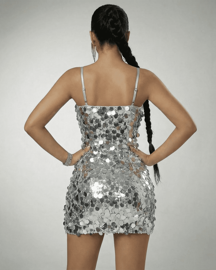 Vestido de fiesta mini con lentejuelas plateadas, ideal para cóctel. Escote Bardot que aporta glamour a la noche.