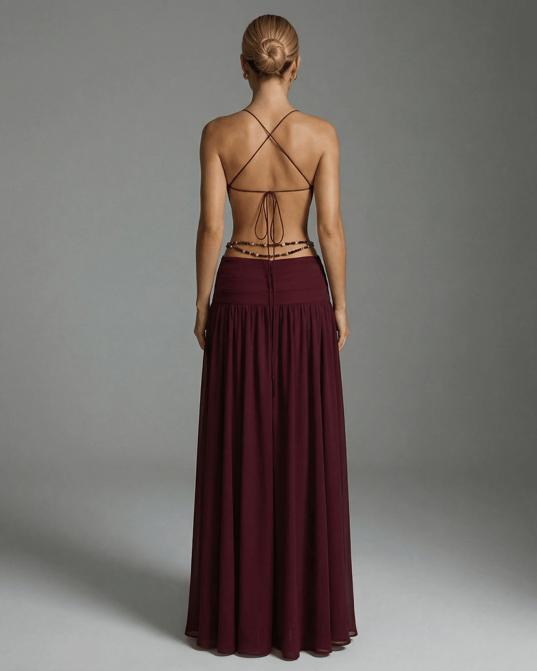 Elegante vestido formal burdeos con adorno metálico y escote V, perfecto para mujer.