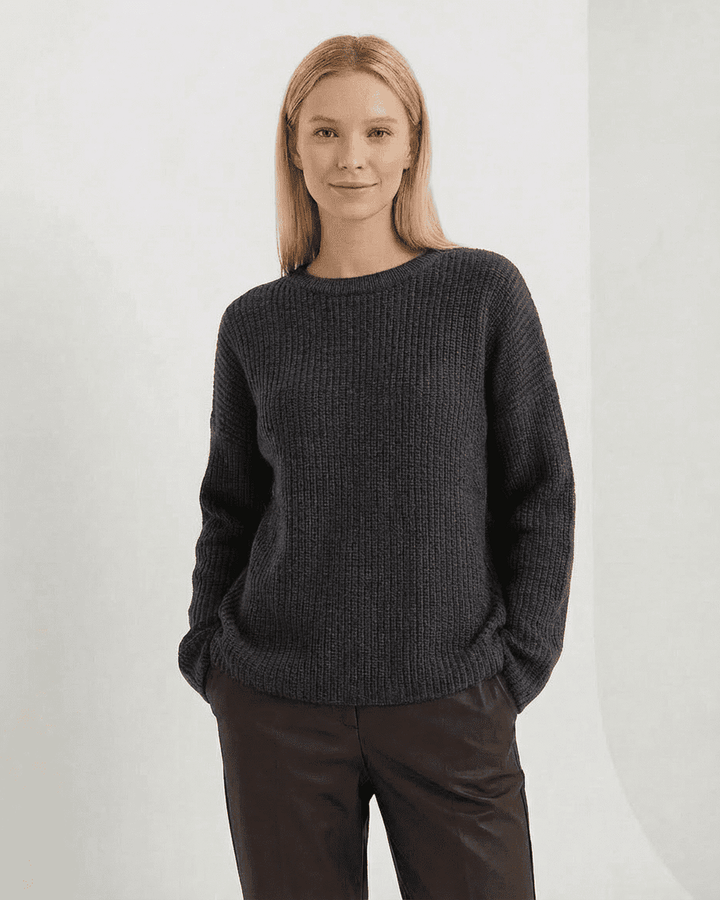 Mujer luciendo suéter blanco de punto grueso, cómodo y casual. Prenda versátil para invierno u otoño.
