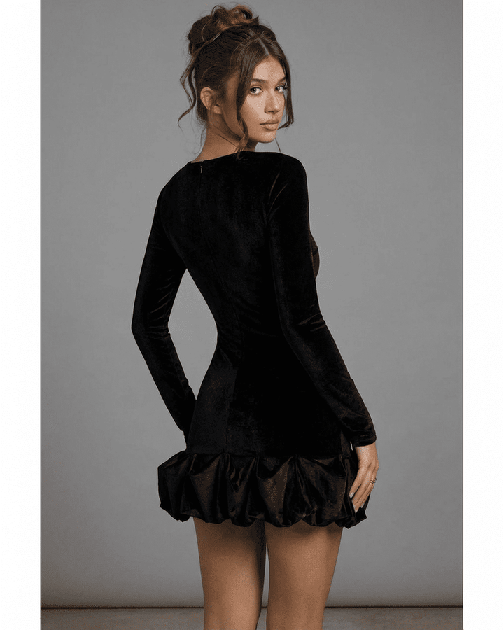 Modelo posando con sofisticado vestido mini negro Velora, perfecto para ocasiones especiales y moda femenina.