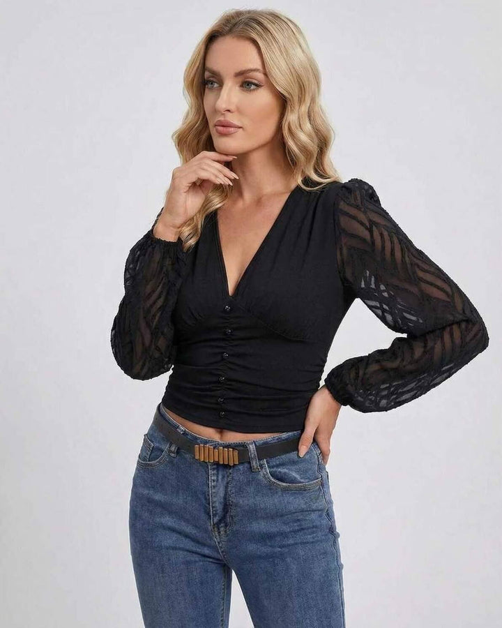 Mujer luciendo suéter negro con escote en V y mangas farol. Estilo sofisticado para noche, fiesta o casual chic.