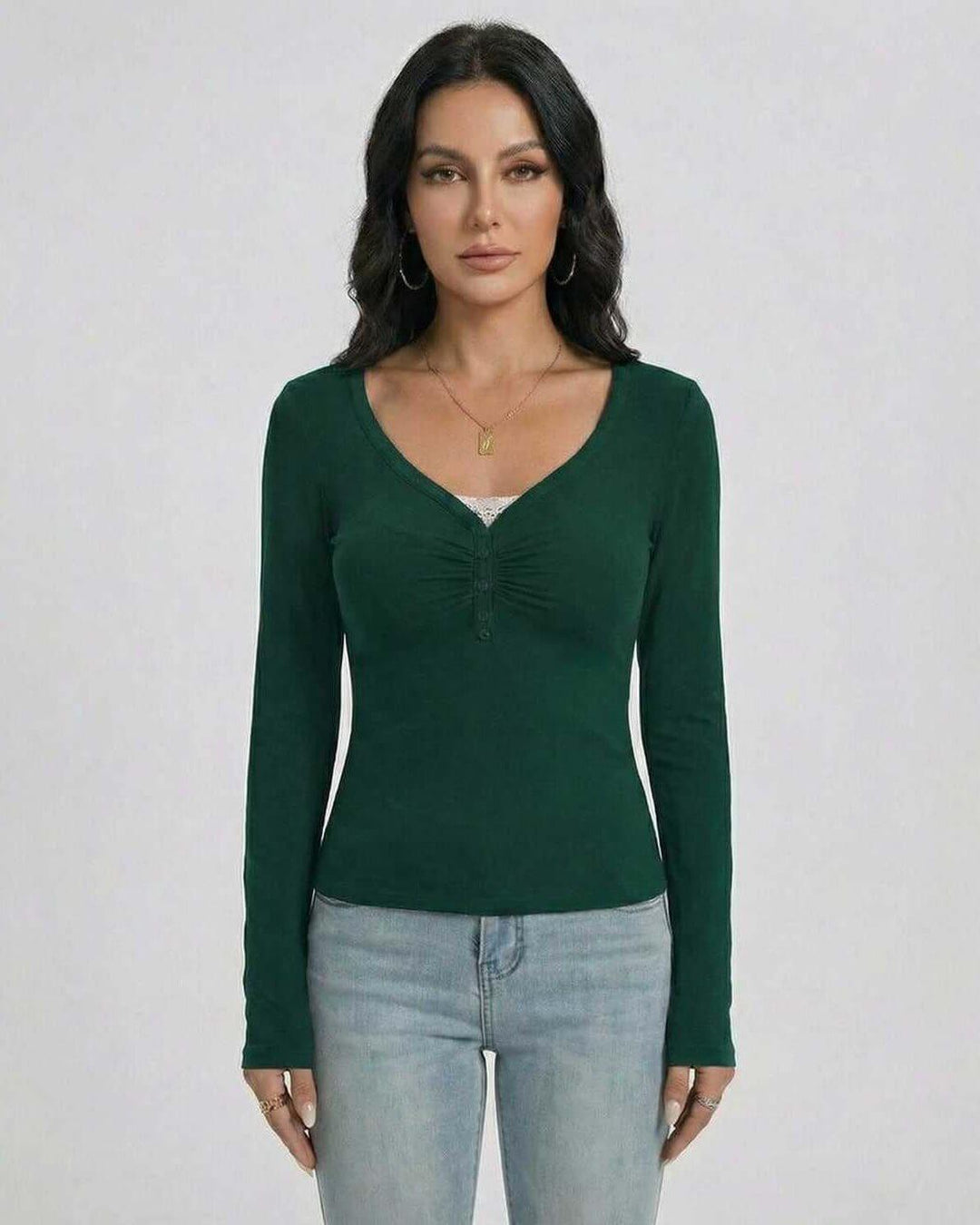 Silueta slim fit en suéter esmeralda de mujer. Cuello en V y manga larga, perfecto para un look otoñal elegante.