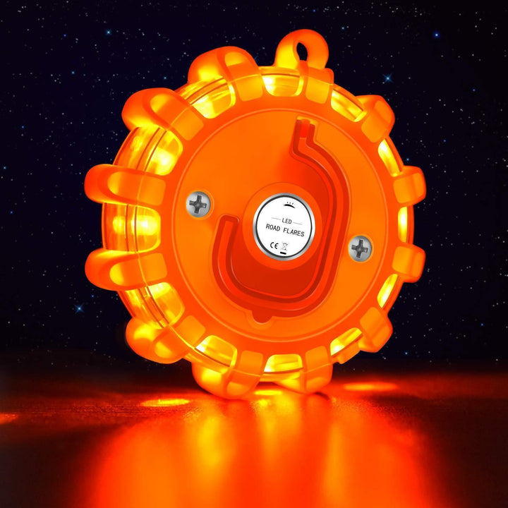 Bengala LED junto a chaleco reflectante y triángulo de emergencia, parte del kit de seguridad automovilística.