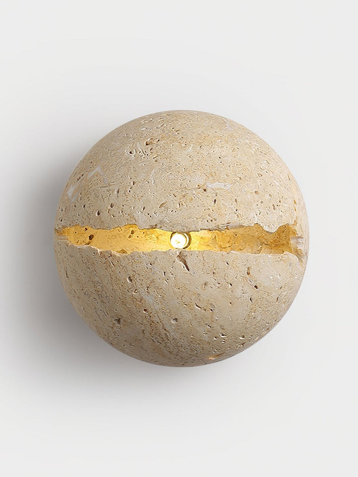 Aplique de pared travertino beige con luz difusa, ideal para iluminación ambiental interior.