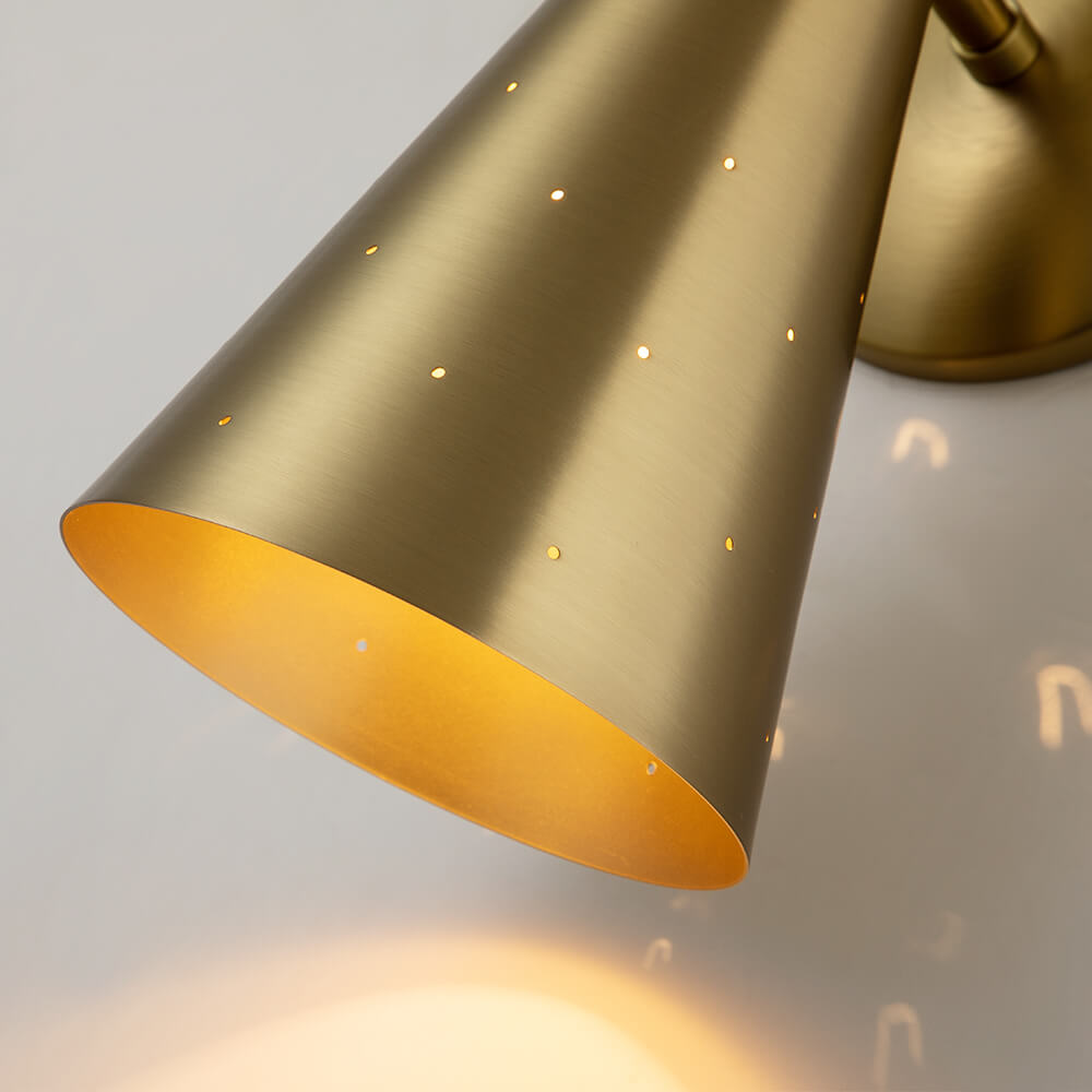 Aplique de pared cono doble, de latón, aporta iluminación cálida y diseño moderno.