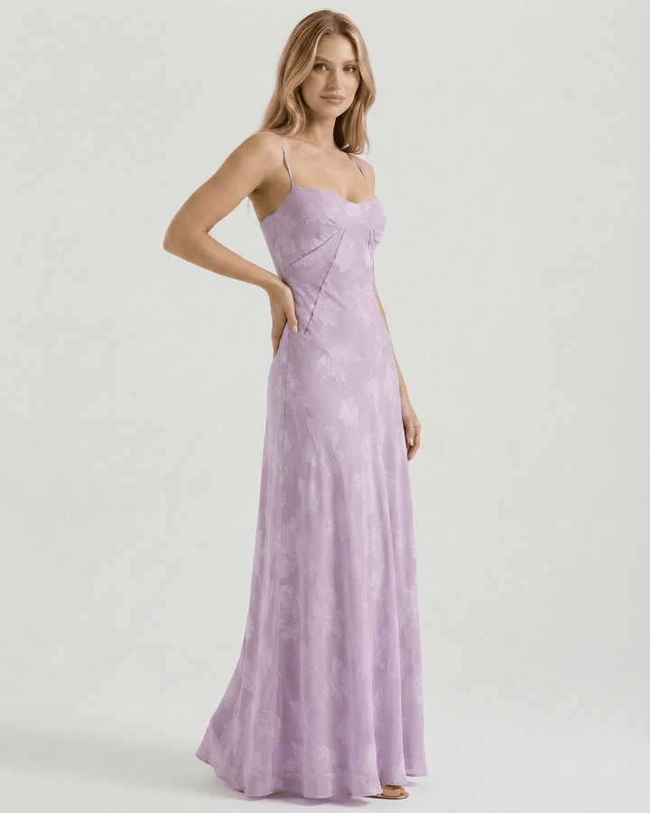 Diseño de vestido maxi floral blanco para mujer, destacando estampado vibrante y lazo en espalda. Estilo romántico.