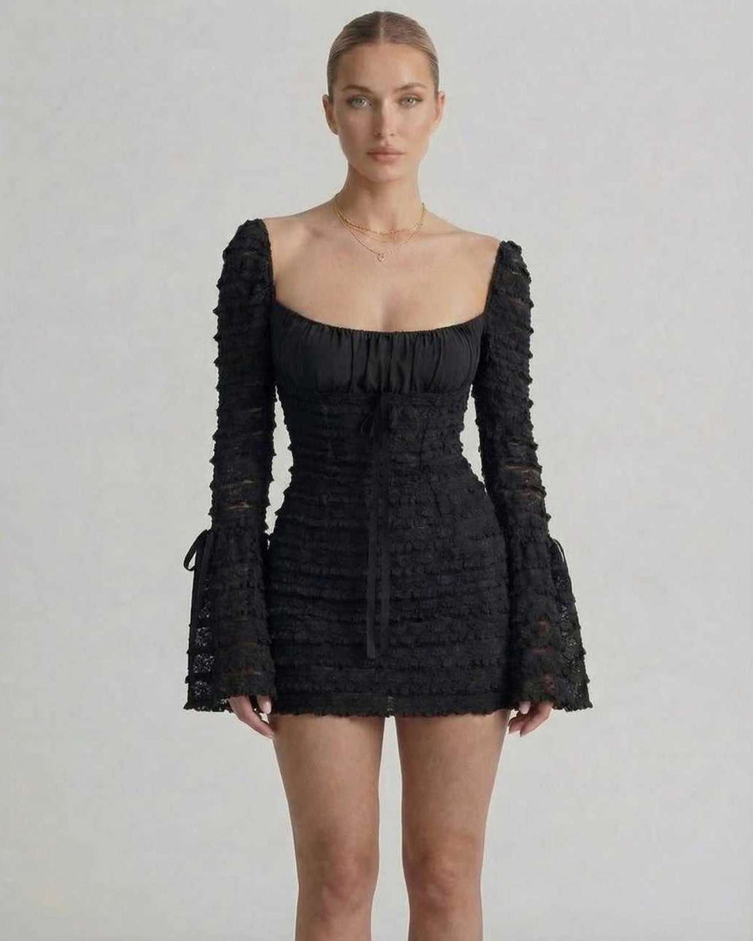 Mini vestido negro de fiesta ajustado, con escote cuadrado y mangas acampanadas. Ropa de mujer, estilo chic.