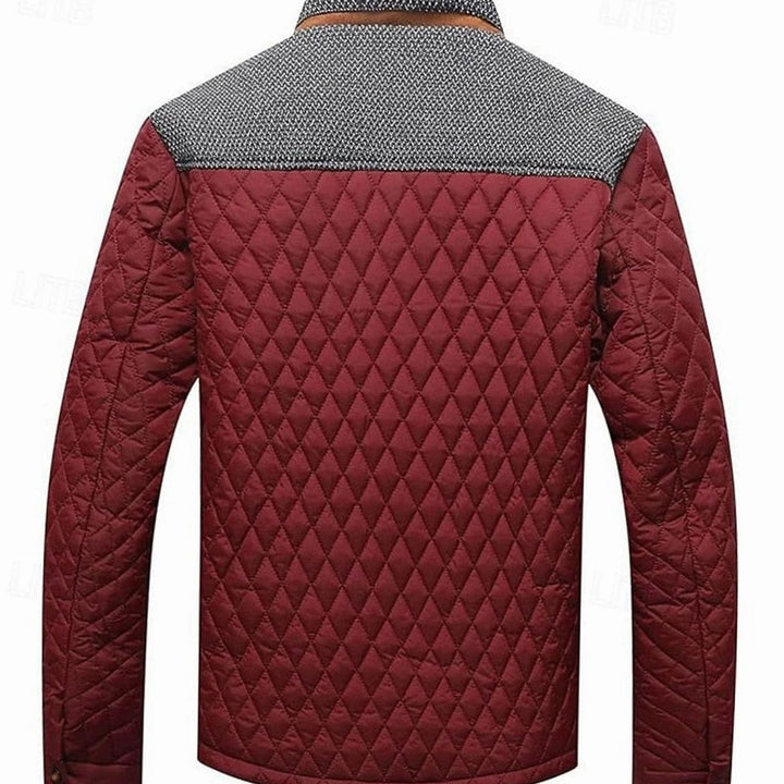 Chaqueta acolchada hombre en color oscuro, cuello mao y botones. Prenda esencial para el frío.